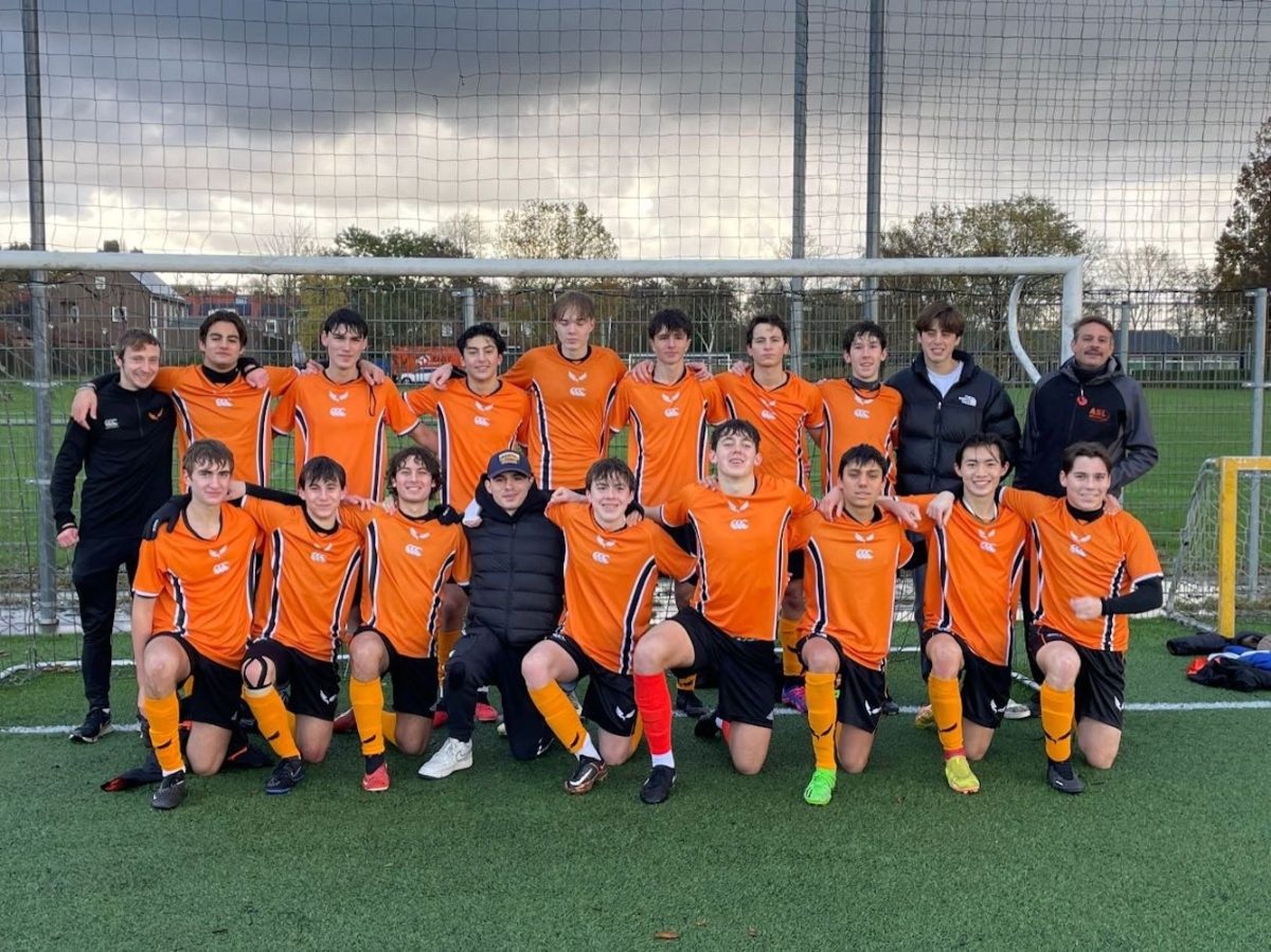 The varsity boys soccer team poses for a team photo.  This photo was taken following their 4-0 win against the Munich International School.